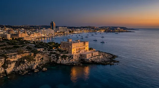 The Malta coastline at blue hour with a historic palace on a headland and the lights of St Julian's behind it